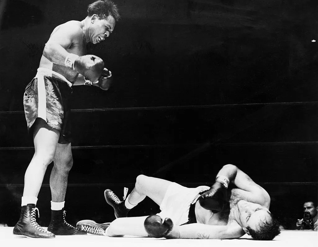 Archie Moore Stands Over Opponent In Ring