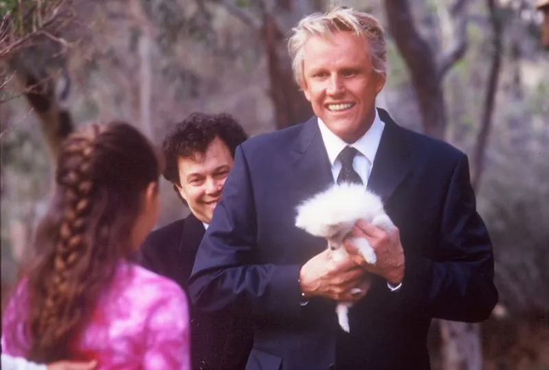 Gary Busey holding the dog Quigley in the movie by the same name