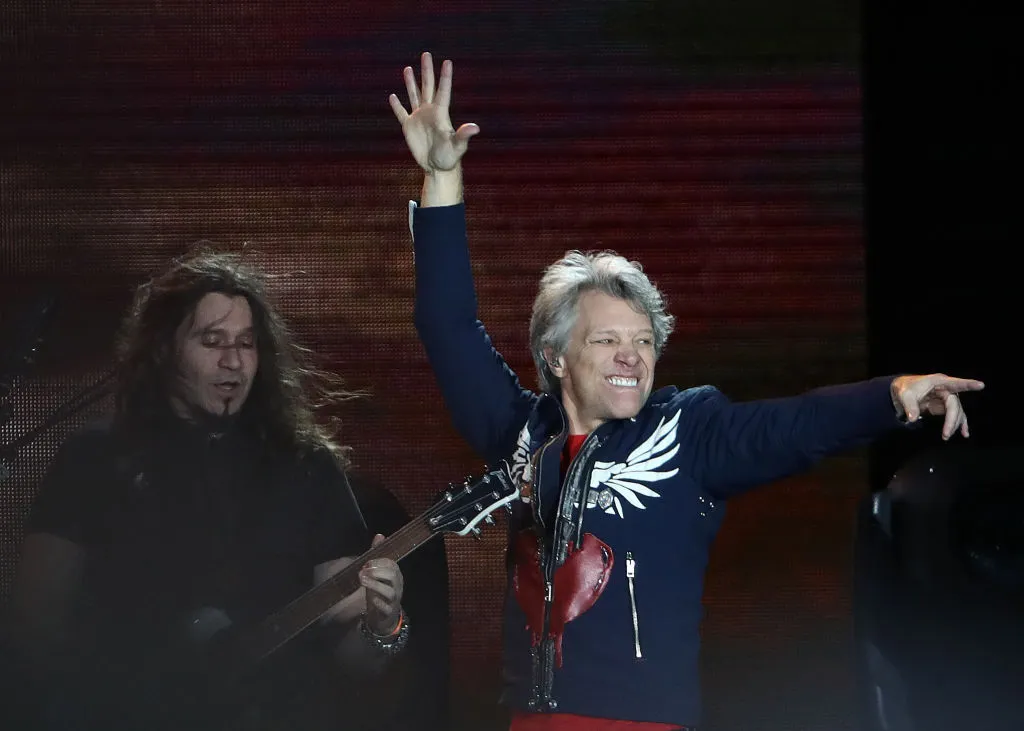 bon jovi on stage pointing and dancing