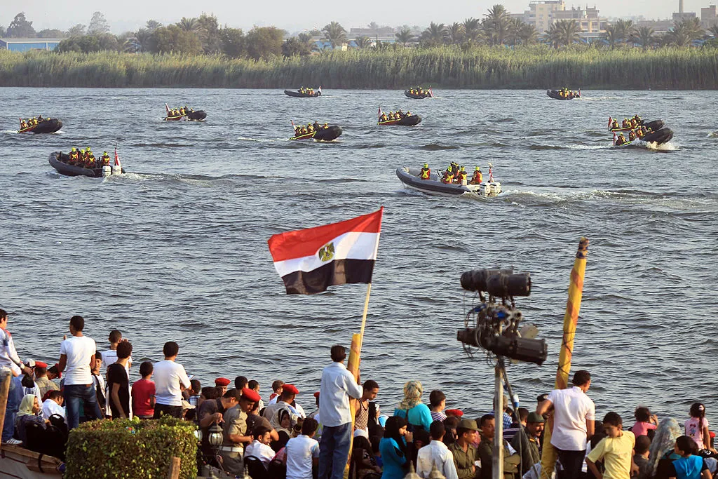 Egyptian spectators look at navy forces performing on the Nile in Cairo