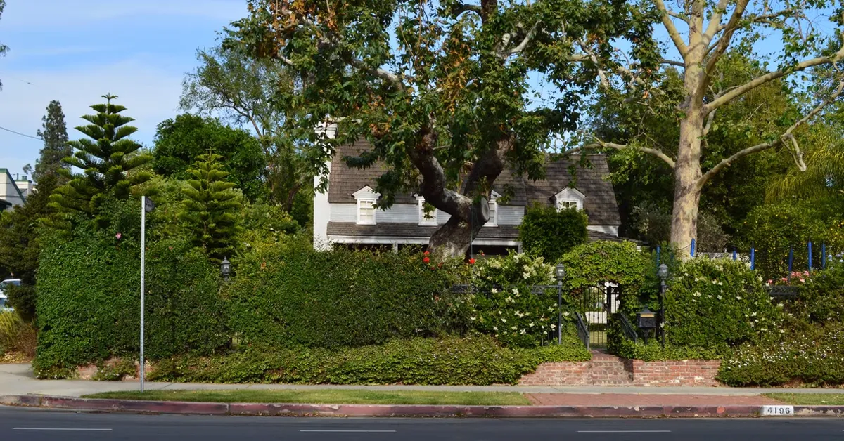 the exterior of the house from boy meets world hidden by large bushes and trees