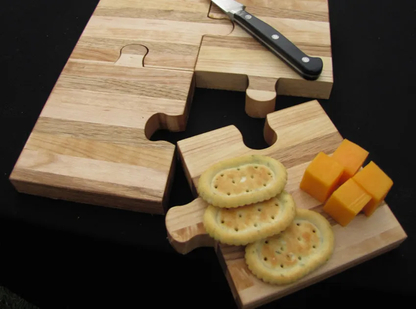 puzzle piece cutting board with crackers and cheese on one piece 
