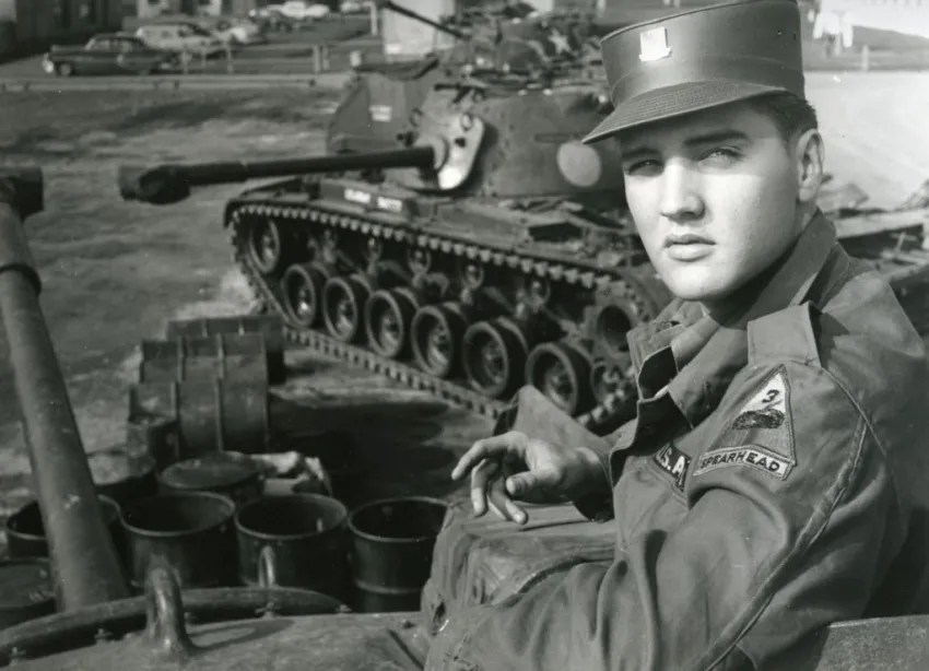 Elvis Presley in front of a tank