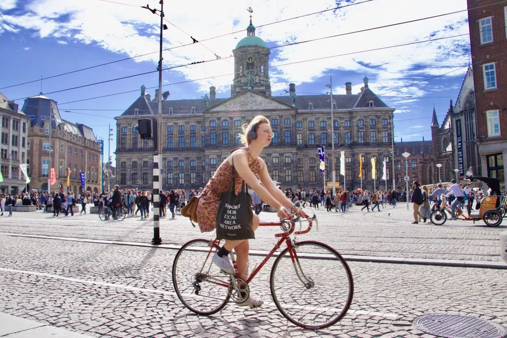 GettyImages-1147419894 A woman rides a bicycle in a street in Amsterdam, Netherlands