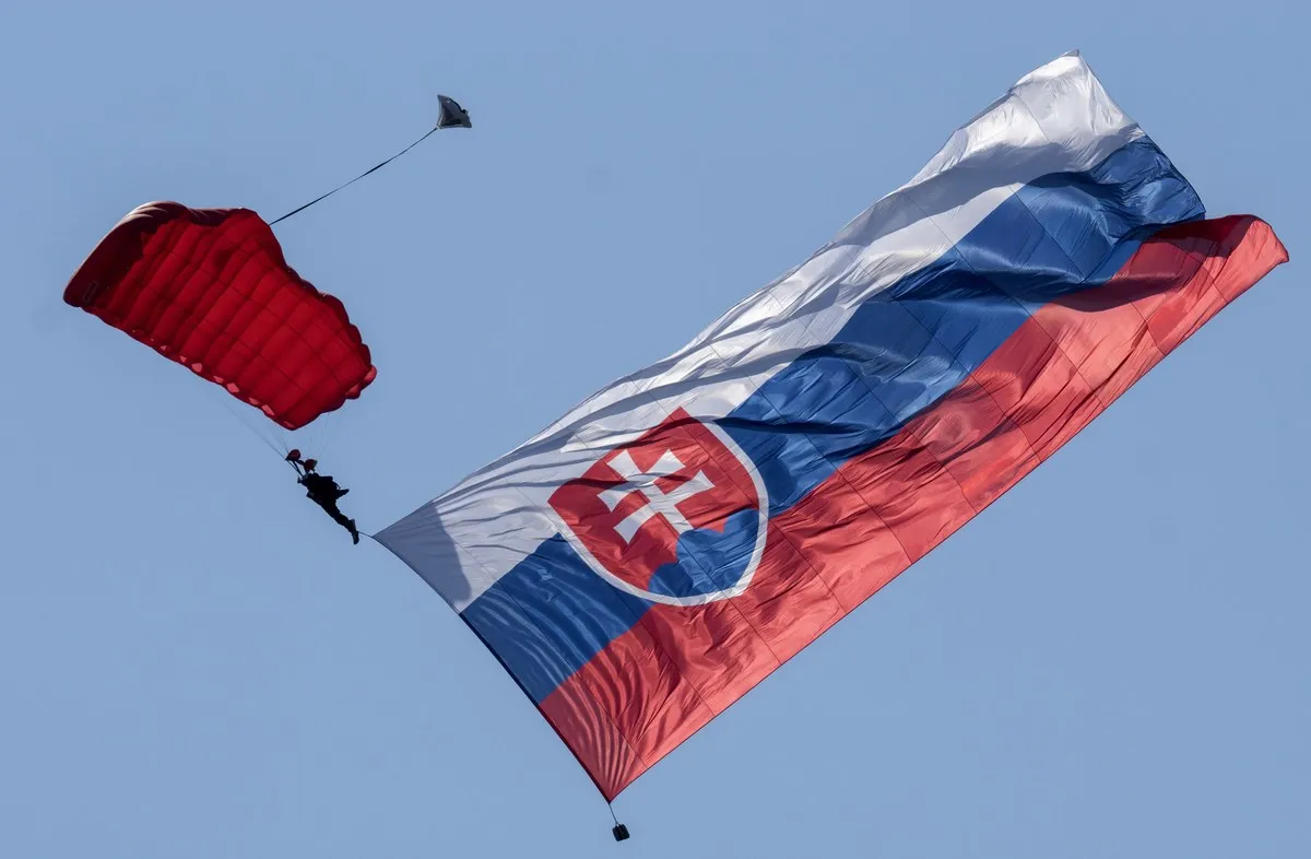 A soldier jumps with parachute and giant Slovak flag (9 meters wide and 16 meters long to commemorate the 71st anniversary of the Slovakia's National Uprising (SNP) during the Slovak International Air Fest SIAF 2015 at the Slovak Airforce Base of Sliac on August 29, 2015.