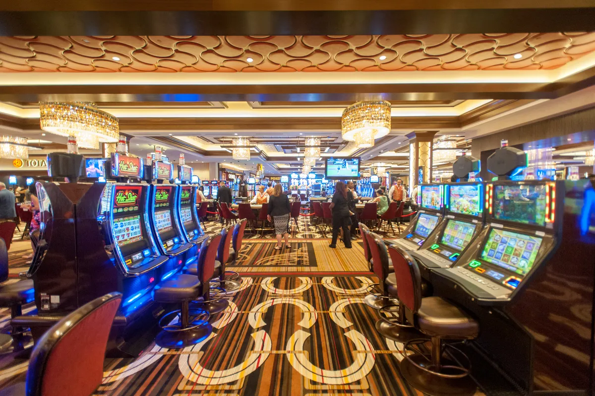 Interior of people in casino gambling on slot machines.