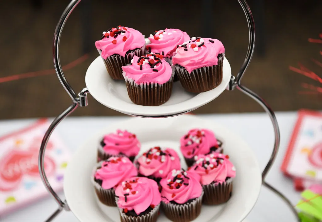 chocolate cupcakes with pink frosting and sprinkles on plates