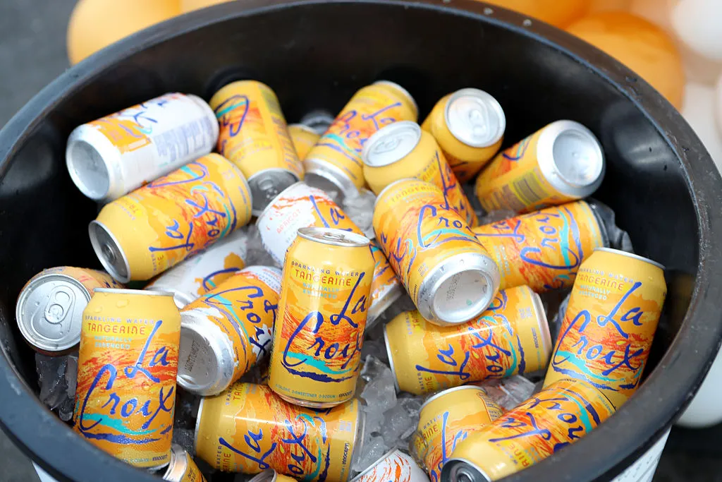 many cans of tangerine lacroix in a black ice bucket