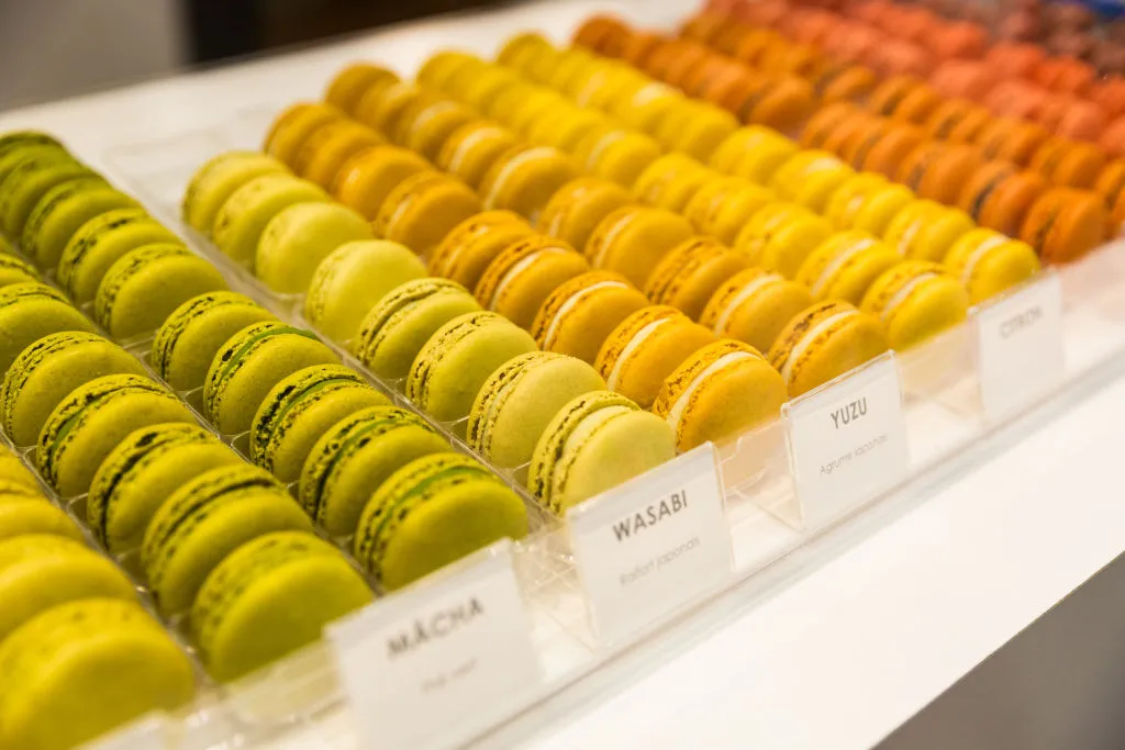 green, orange, yellow, and red macarons on a shelf