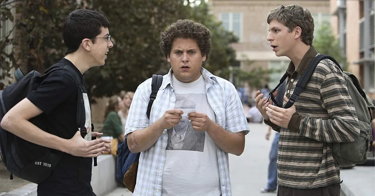 christopher mintz-plasse, jonah hill, and michael cera outside a school in superbad