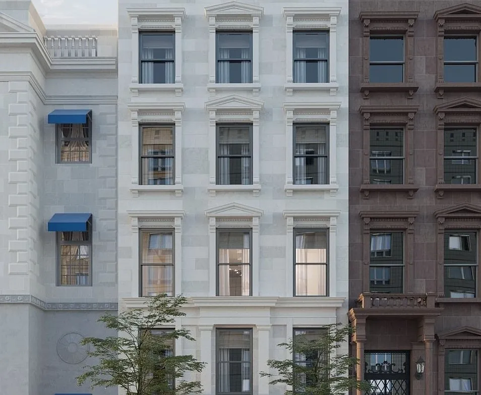 The white mansion boasts four rows of three large, rectangular windows apparent from the street view.