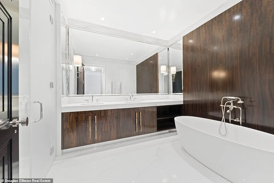 A large bathroom features double sinks, wood cabinets, and a modern oval sub with a handheld washing hose.