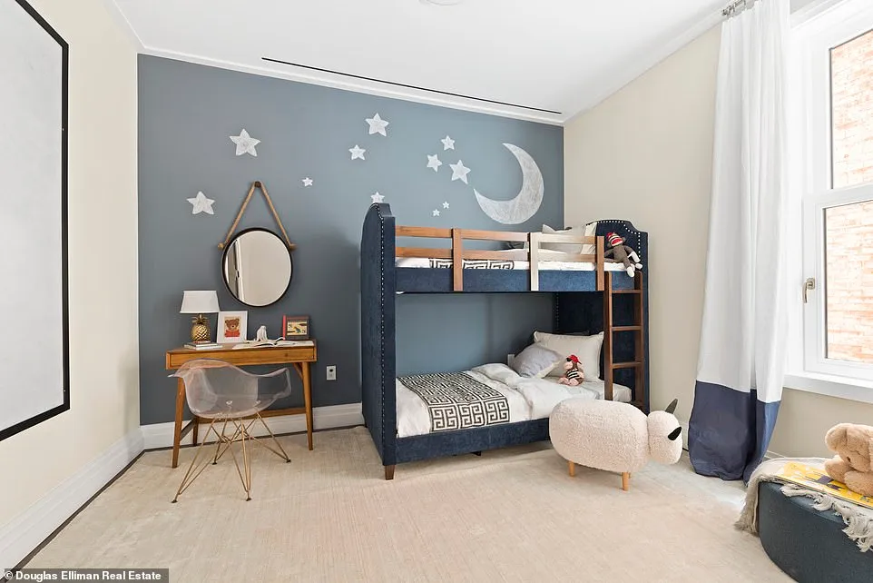 The room has a chalk-blue accent wall, a small desk, and designer bunkbed.