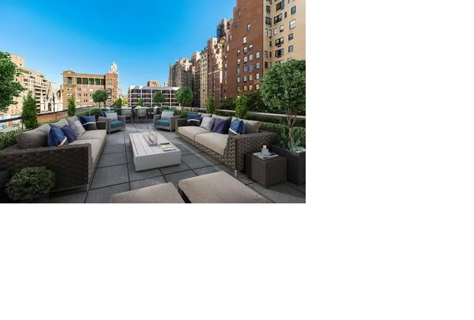 Another outdoor space on the roof shows two large couches the face one another, pointing to another long table and skyscraper views all around.