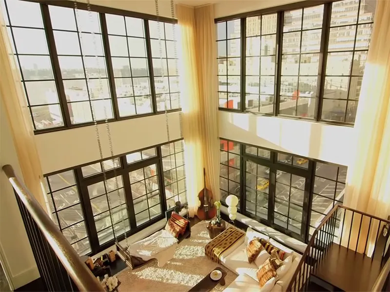 Floor to ceiling windows showcase the Manhattan view from the living room and upstairs