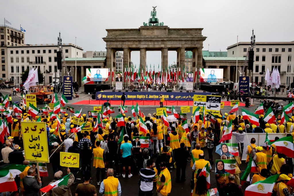 Ralliers gather before the Brandenburg Gate wearing the colors of Iran