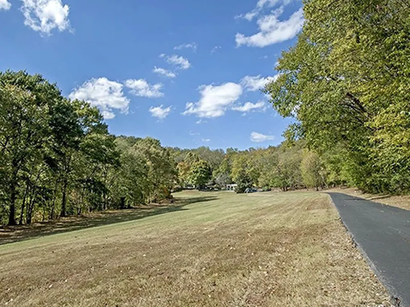 A long driveway traces the forest trees leading to the Tennessee home