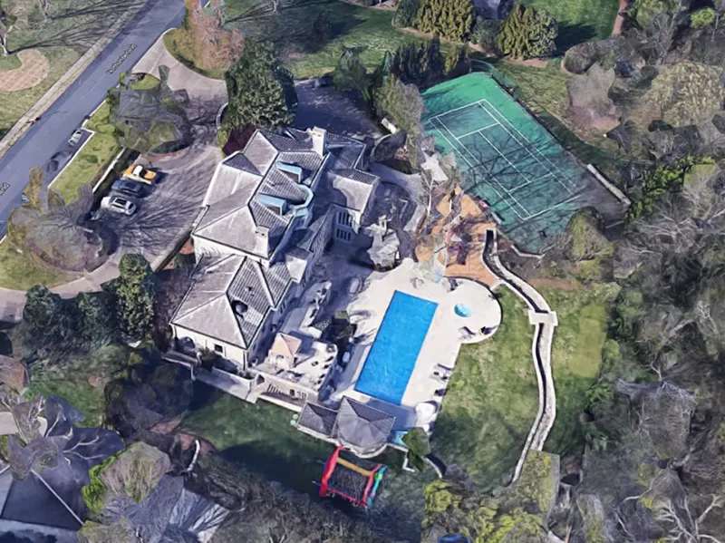 An aerial view shows a giant Nashville mansion, pool, and tennis court