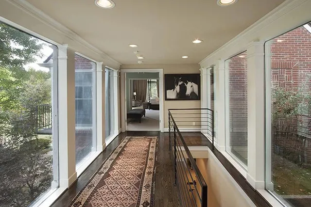 A hallway leading from the living room to the master suite is lined with giant windows