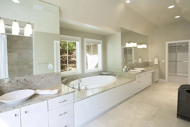 The master bathroom is long and expansive with two sinks and a tub lining one side