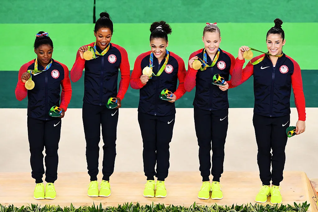simone biles on the medal stand with fellow gymnasts