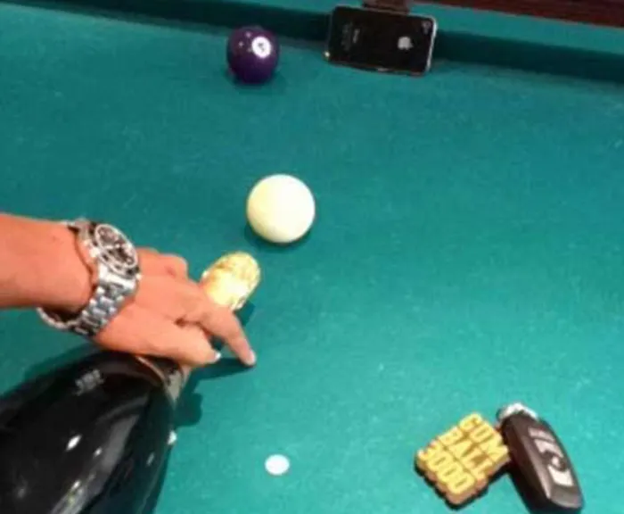 Person destroys an iPhone 4S with a champagne bottle and pool table.