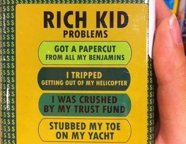 Tin lists rich kid problems: getting a papercut from benjamins, tripping out of a helicopter, crushed by trust fund, and stubbing their toe on their yacht.