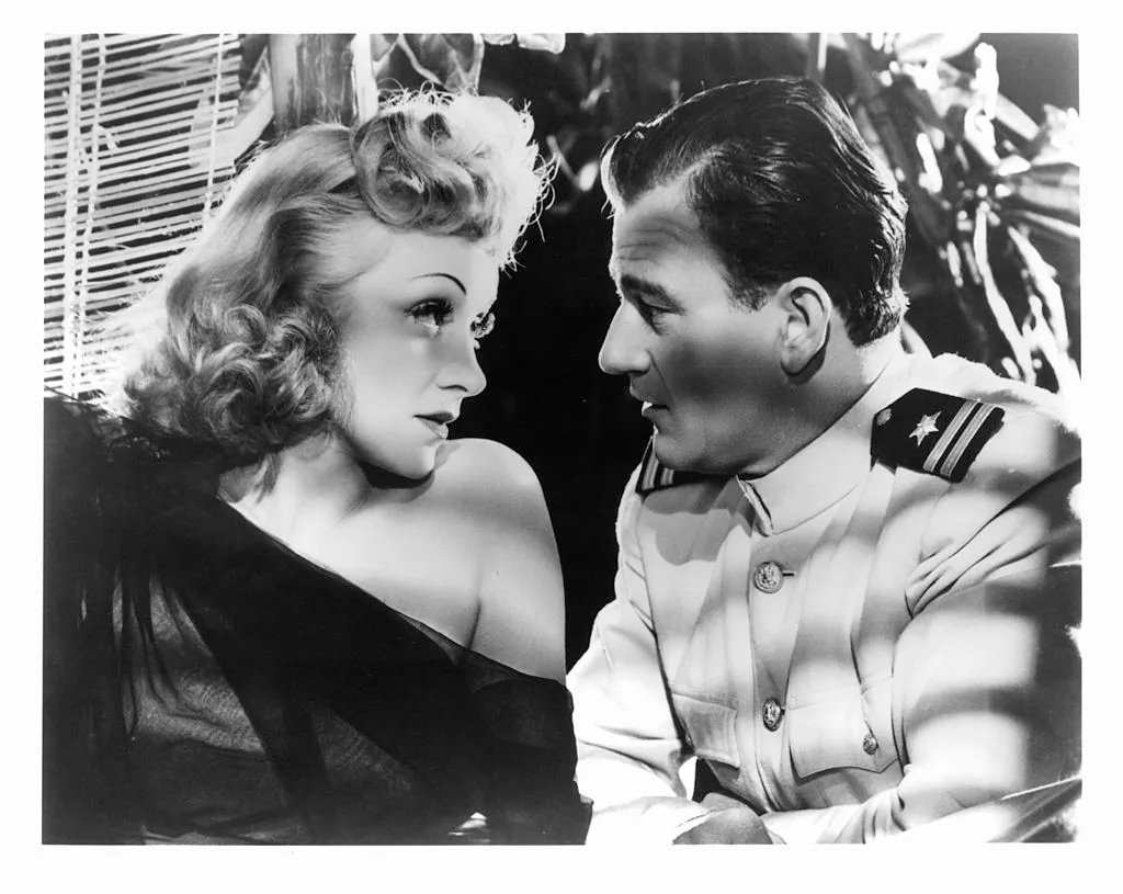 Marlene Dietrich and John Wayne gaze into each others eyes in a scene from the film 'Seven Sinners