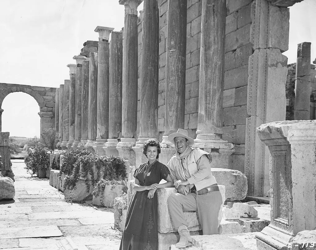Portrait of actors John Wayne and Sophia Loren amongst Roman ruins