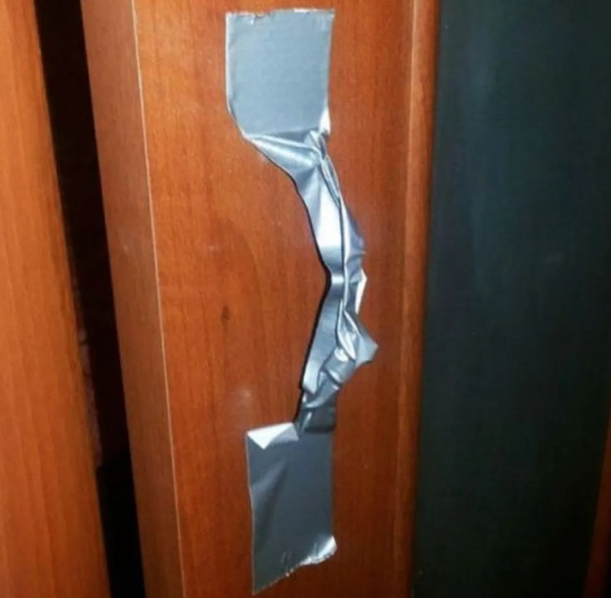 person uses duck tape as a door handle