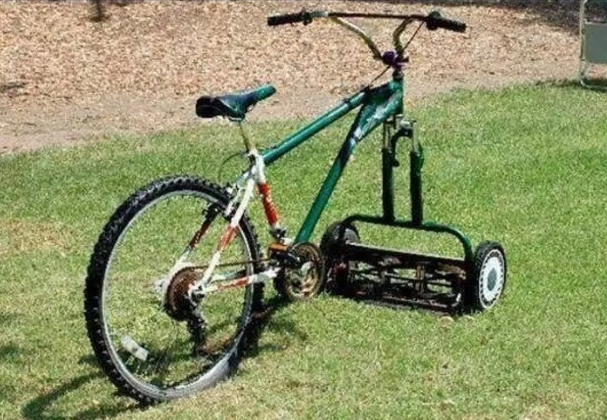Person attached manual lawnmower to front of bicycle instead of wheel