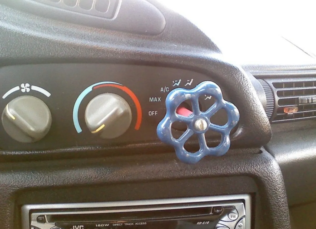 person uses outdoor pipe control in car for air conditioning knob