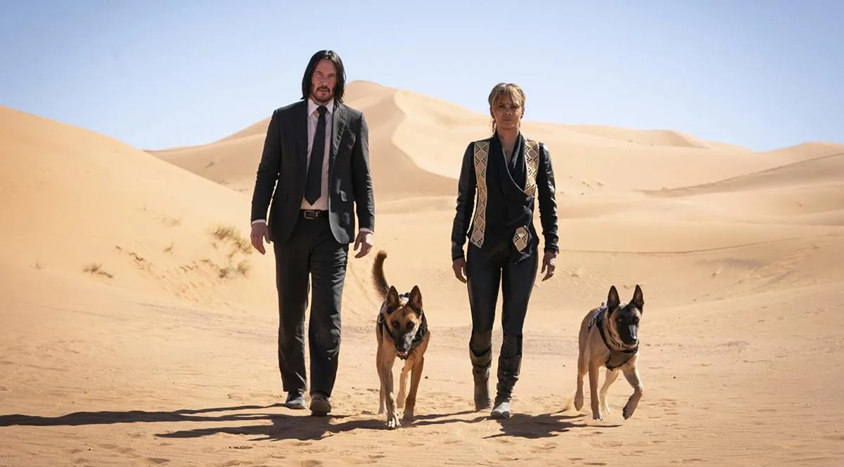 keanu reeves and halle berry walking in a desert with two german shepards