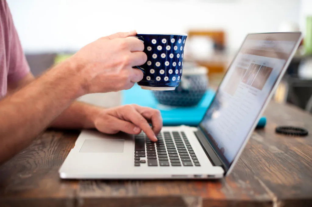 A computer user with a coffee mug is seen in this photo illustration
