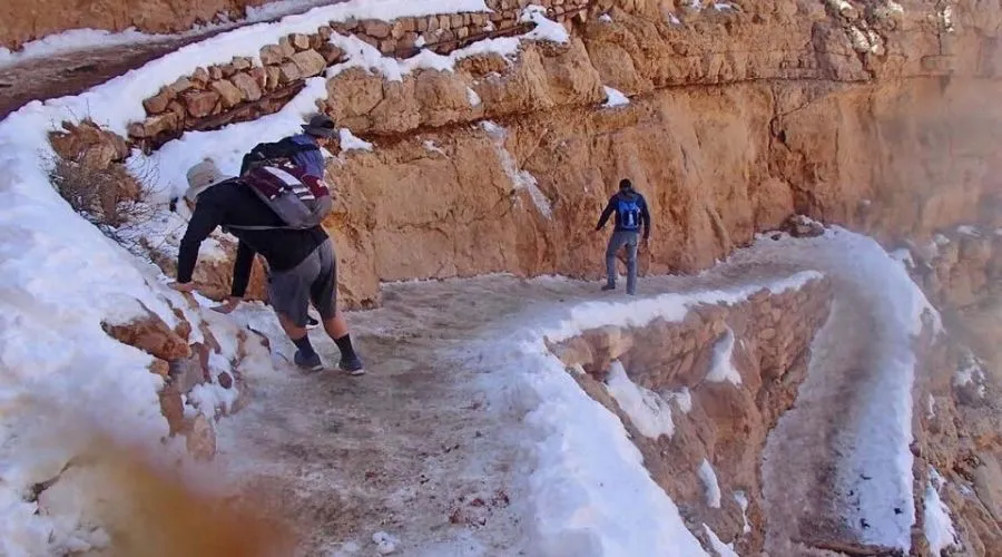 a person wore running shoes to walk up the grand canyon which is covered in ice