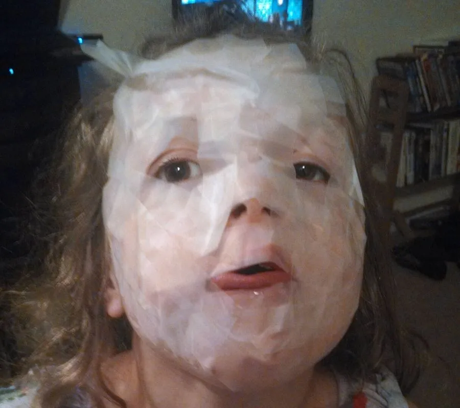 a little girl put tape all over her face
