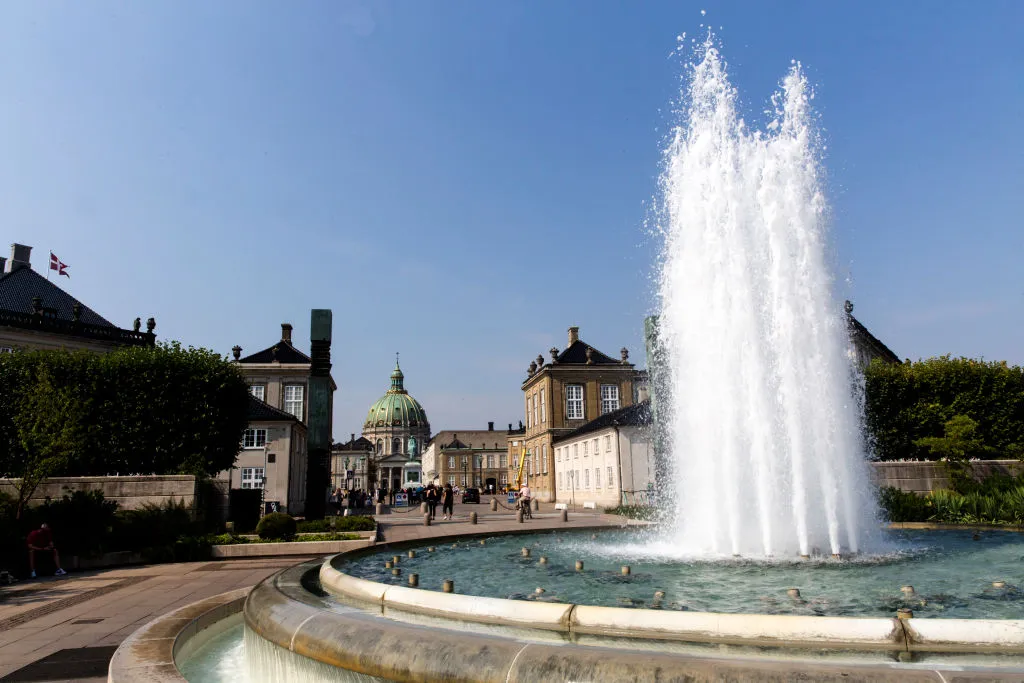 A fountain sits at the mouth of a town square in Denmark. 