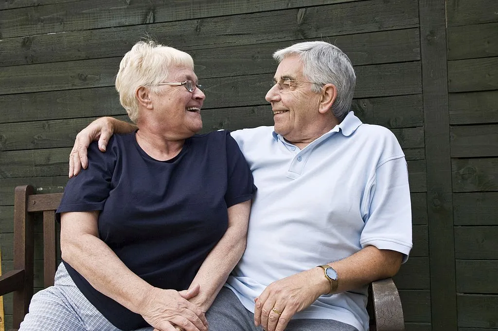 An older couple smiles at one another.