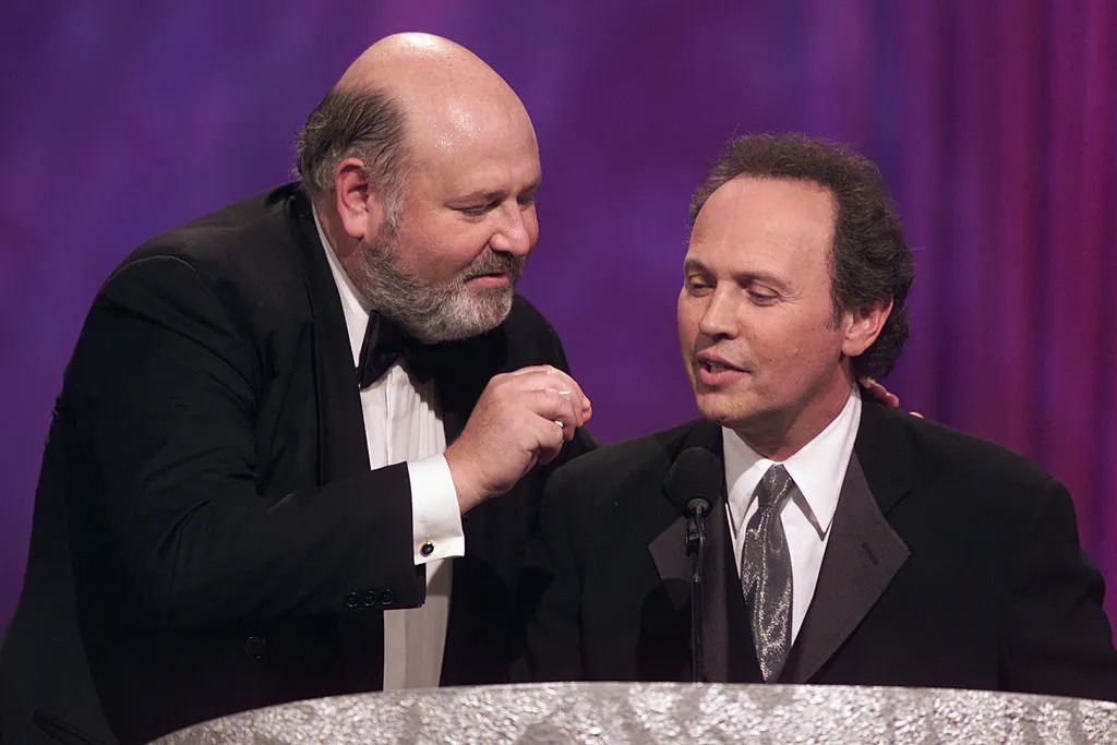 Rob Reiner and Billy Crystal stand at a podium onstage.