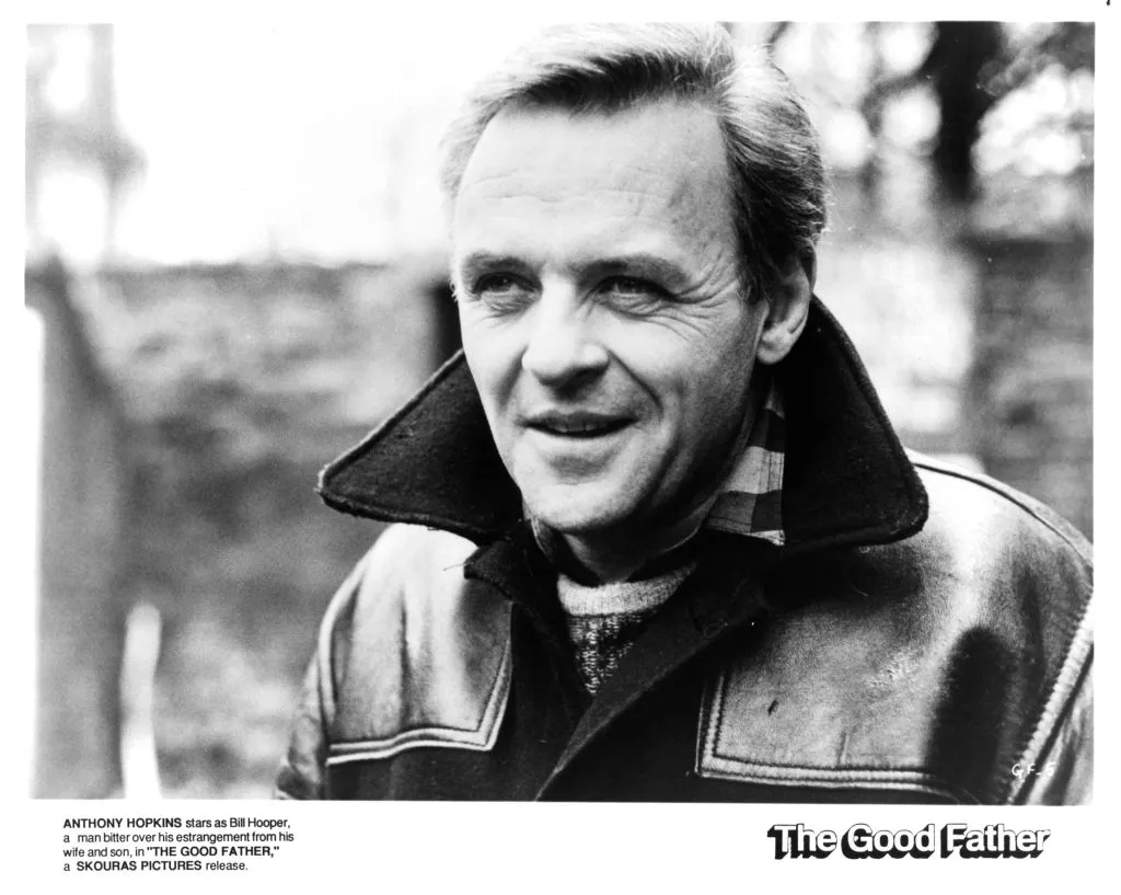 Anthony Hopkins smiles in a black and white photo.