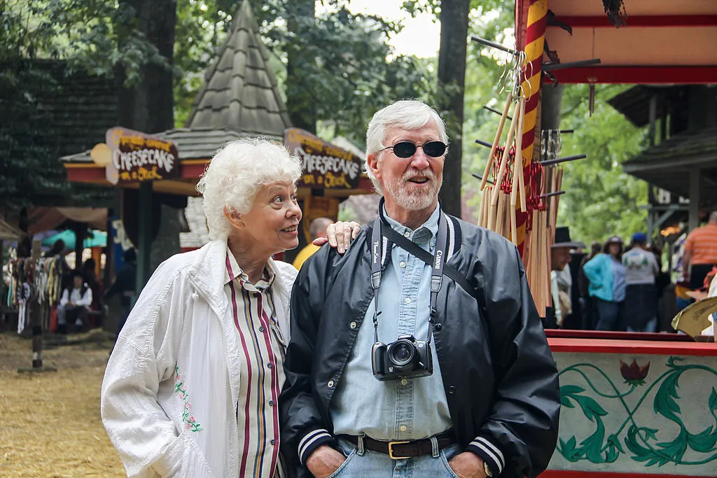 An elderly couple enjoys a festival.