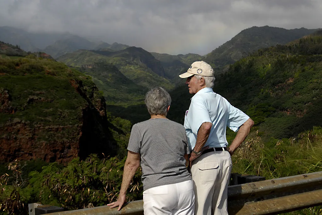 A couple overlooks a hillside.