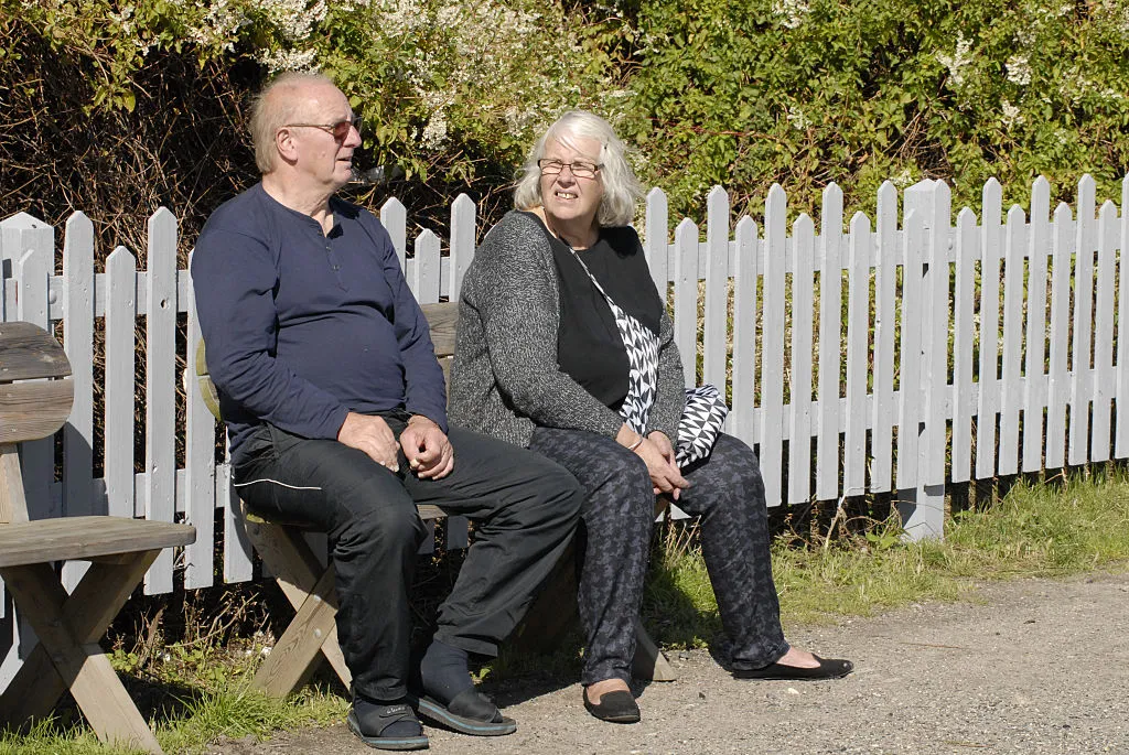 An older couple sits on a bench.