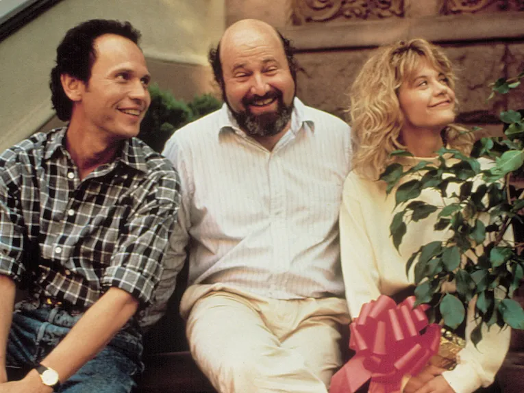 Rob Reiner sits and smiles with his leads.