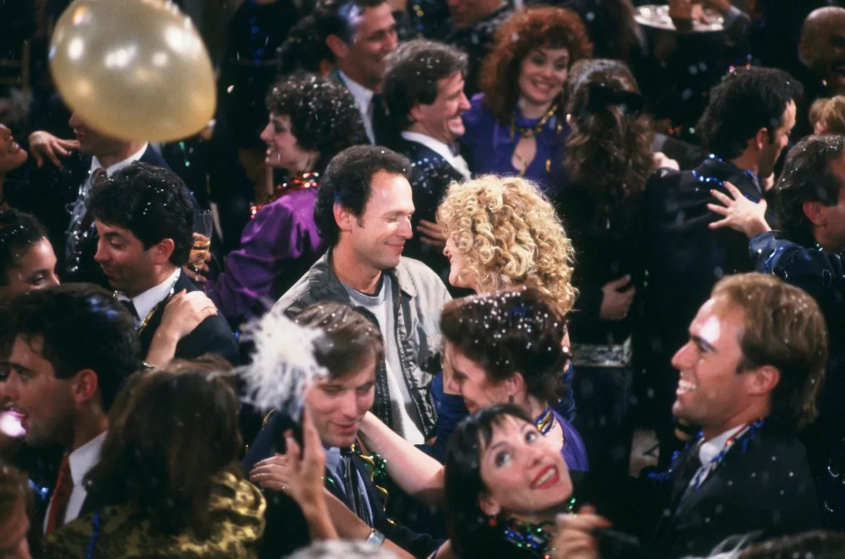 Harry and Sally smile at one another in the middle of a crowd on New Year's Eve.
