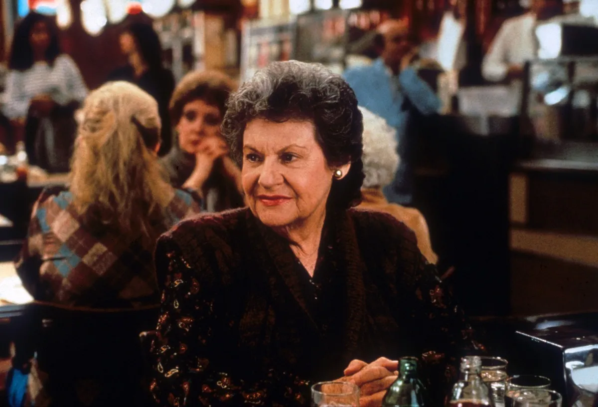 Estelle Reiner sits in a restaurant while filming When Harry Met Sally.