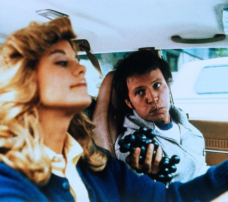 Harry offers Sally some grapes while she drives.