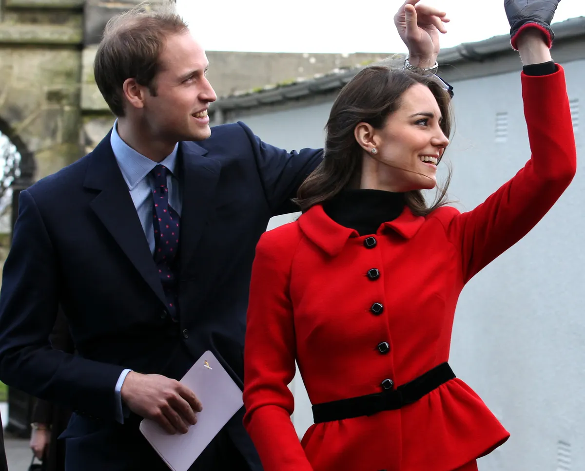 Prince William and Kate Middleton wave as they pass St Salvator's halls during a visit to the University of St Andrews.