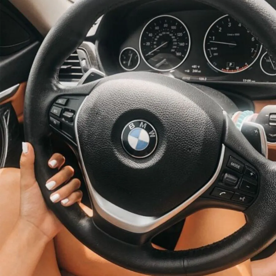 woman's hand holding onto BMW steering wheel