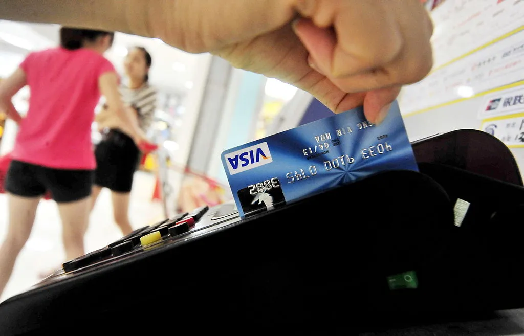 a man swiping his visa credit card in a machine